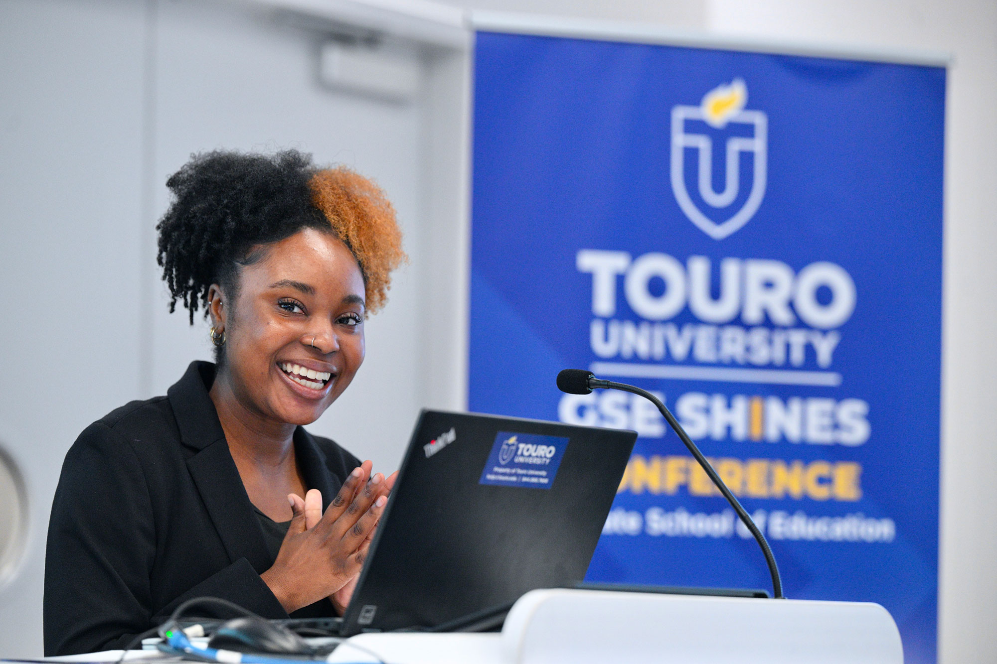 Student smiling while presenting at conference