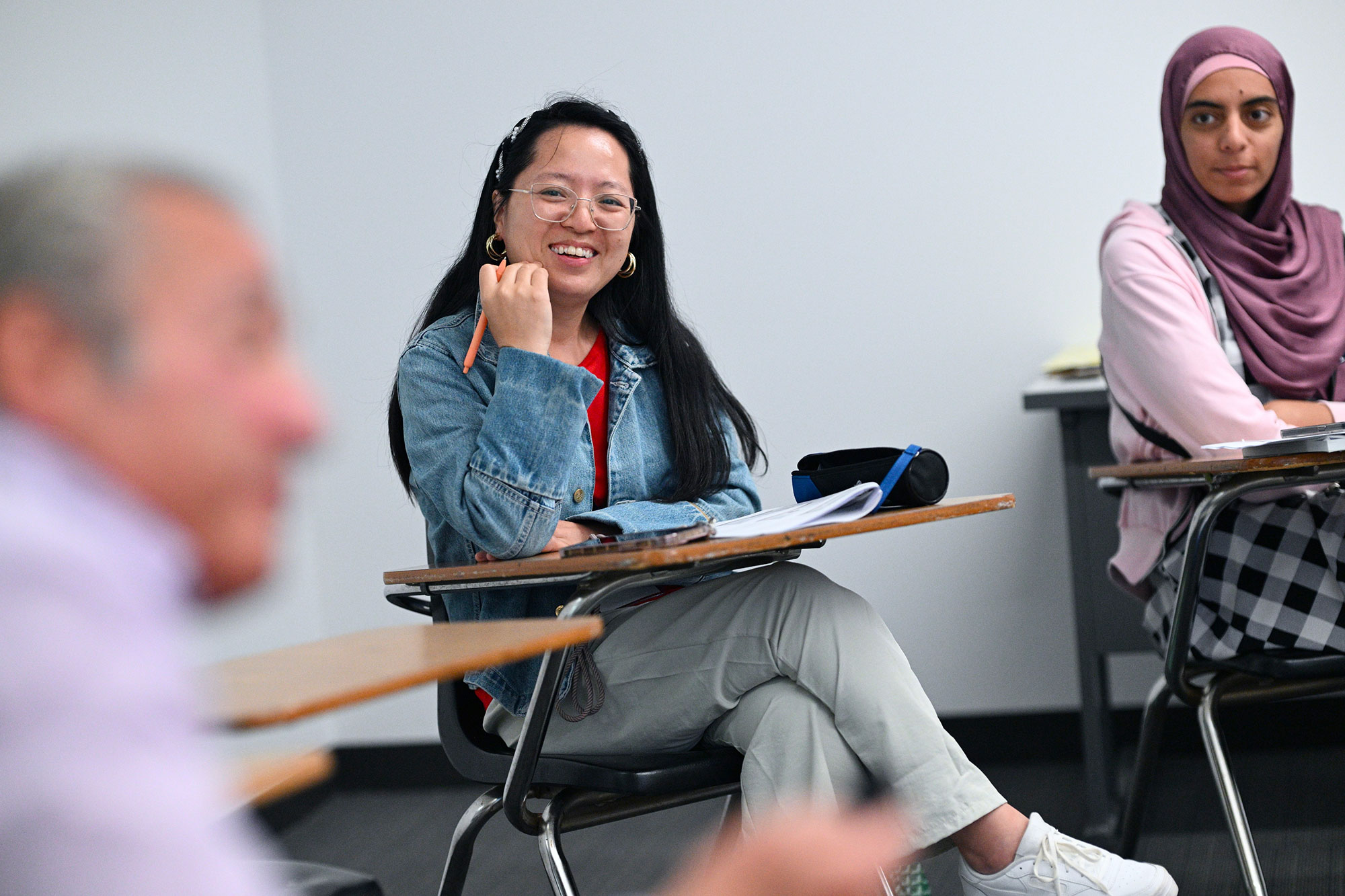 GSE student smiling during class while sitting near professor